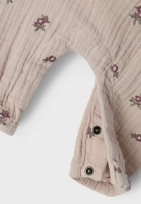 Light pink cotton garment with floral embroidery, featuring ribbed texture and snap fasteners on the cuff for adjustability and ease of wear.