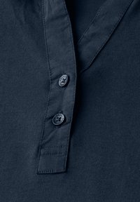 Námořnická modrá košile s jemnou strukturou, se zapínáním na knoflíky a dvěma černými knoflíky s označením "Cecil". Jednoduchý design, bez vzorů.