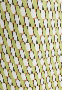 Textil med ett mönster av sammankopplade trianglar i grönt, vitt och orange, som har en strukturerad yta och en livfull geometrisk design.