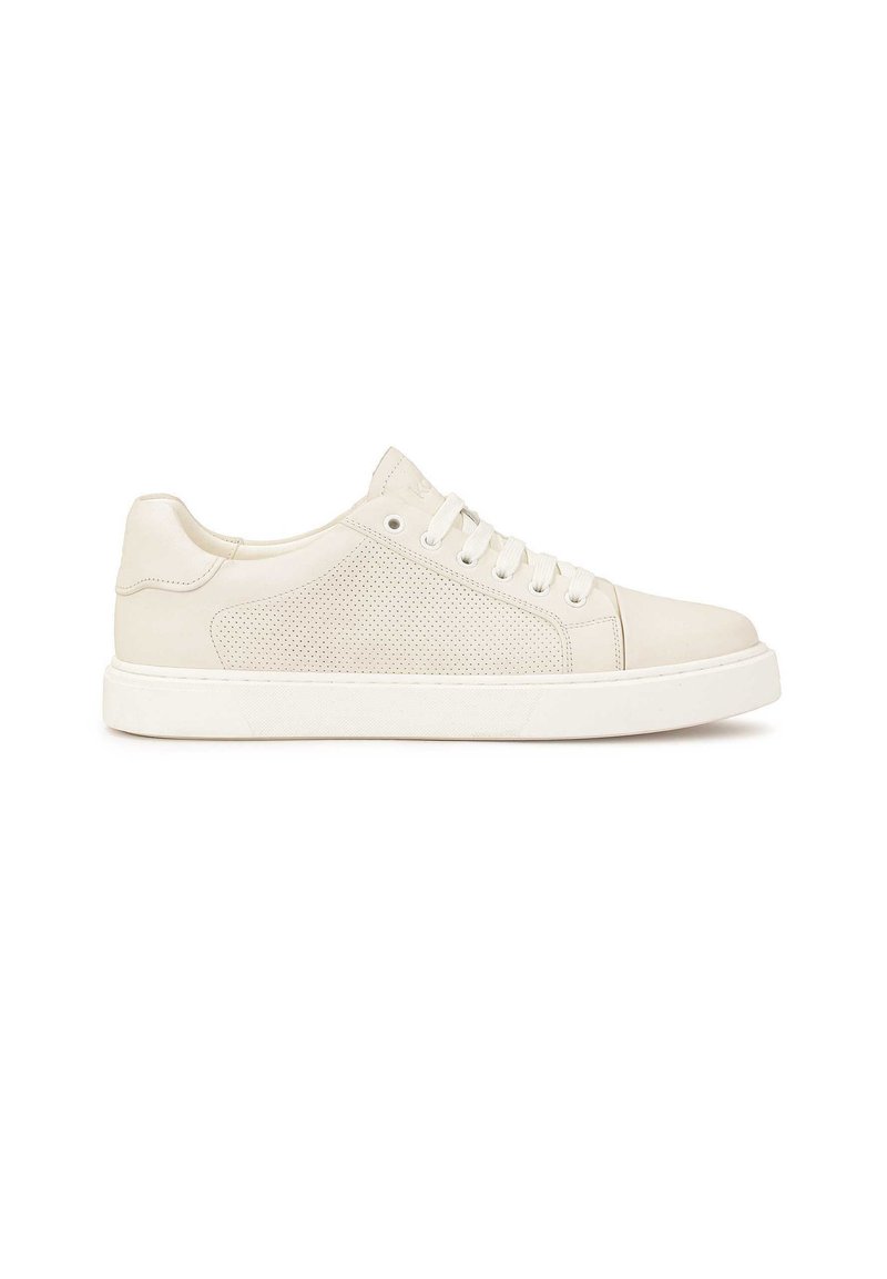 Zapatilla blanca de cuero con detalles perforados en los laterales, suela de goma y cordones planos. Presenta un acabado suave y un diseño de punta redondeada.