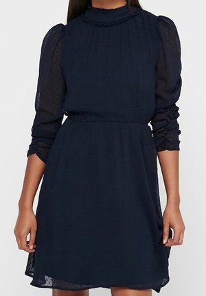 Marineblaues Kleid mit hohem Ausschnitt, gerafftem Besatz und transparenten, aufgeblasenen Ärmeln. Der Rock ist an der Taille anliegend und fällt sanft.