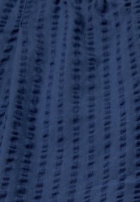 Marine textiel met een structuur en horizontale strepen, met een zachte afwerking en variabele dikte. Ideaal voor kleding of decoratieve toepassingen.