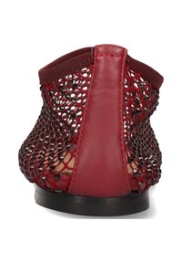 Czerwone siatkowe sandały z gładką skórzaną piętą i elastycznym wierzchem, płaską czarną podeszwą oraz ozdobami z koralików na siatkowym wzorze.