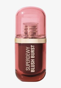 Una tapa de cúpula transparente rosa sobre una botella cilíndrica de color rojo oscuro con acentos dorados, etiquetada como "SUPERDEWY BLUSH BURST" en texto blanco.