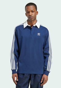 Navy blue long-sleeve polo shirt with a white collar, three white stripes on sleeves, and an Adidas logo on the chest.