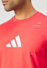 adidas Performance PADEL CAT GRAPHIC TEE - Sports T-shirts - semi lucid red