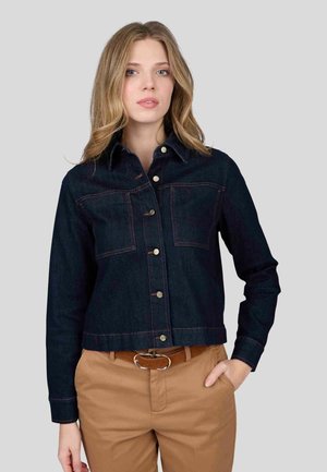 Veste en denim bleu foncé avec deux poches poitrine, fermeture à boutons et un design légèrement court. Présente des coutures contrastées et un col classique.
