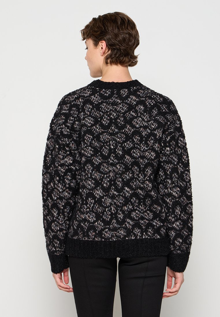 Gebreide trui in zwart en grijs met een gestructureerd dierenprint. Heeft een rondhals, een oversized pasvorm en geribbelde zoom en manchetten.