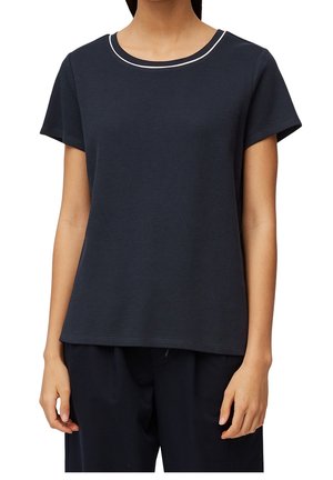 Vrouw draagt een effen donker marineblauw T-shirt met korte mouwen en een dunne witte streep op de ronde hals.