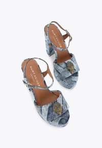 Sandali in denim con platform caratterizzati da una fascia larga con un accento decorativo in tonalità oro, punta aperta e tacco spesso per maggiore stabilità.