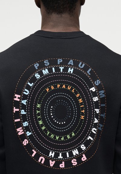 Μαύρο φούτερ με κυκλικά πολύχρωμα μοτίβα κειμένου, «PS PAUL SMITH», με διάφορα μεγέθη γραμματοσειράς και ραφές ως διακοσμητικά στοιχεία.