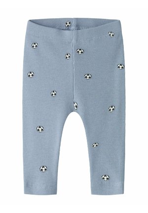 Pantalones de bebé azul claro acanalados con patrones dispersos de pequeños balones de fútbol en blanco y negro.