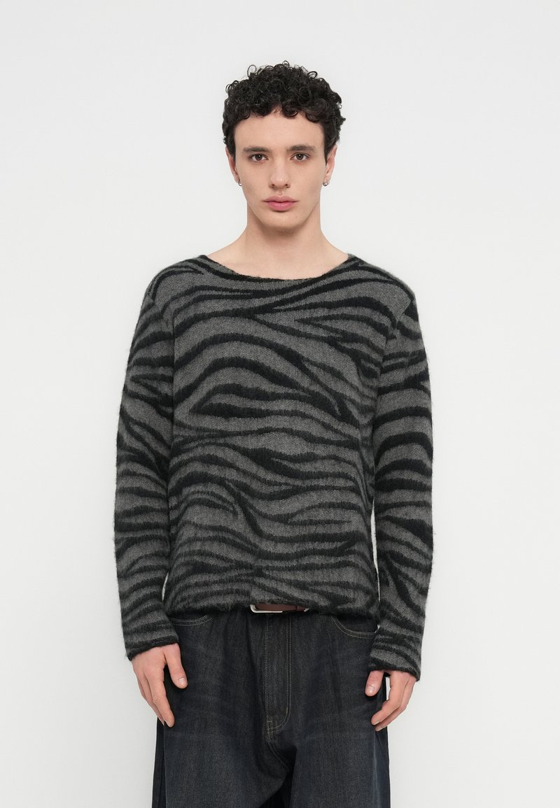 Μαύρο και γκρι ριγέ πουλόβερ με άνετη εφαρμογή, φαρδύ λαιμό και μακριά μανίκια, κατασκευασμένο από απαλό, υφασμένο ύφασμα.