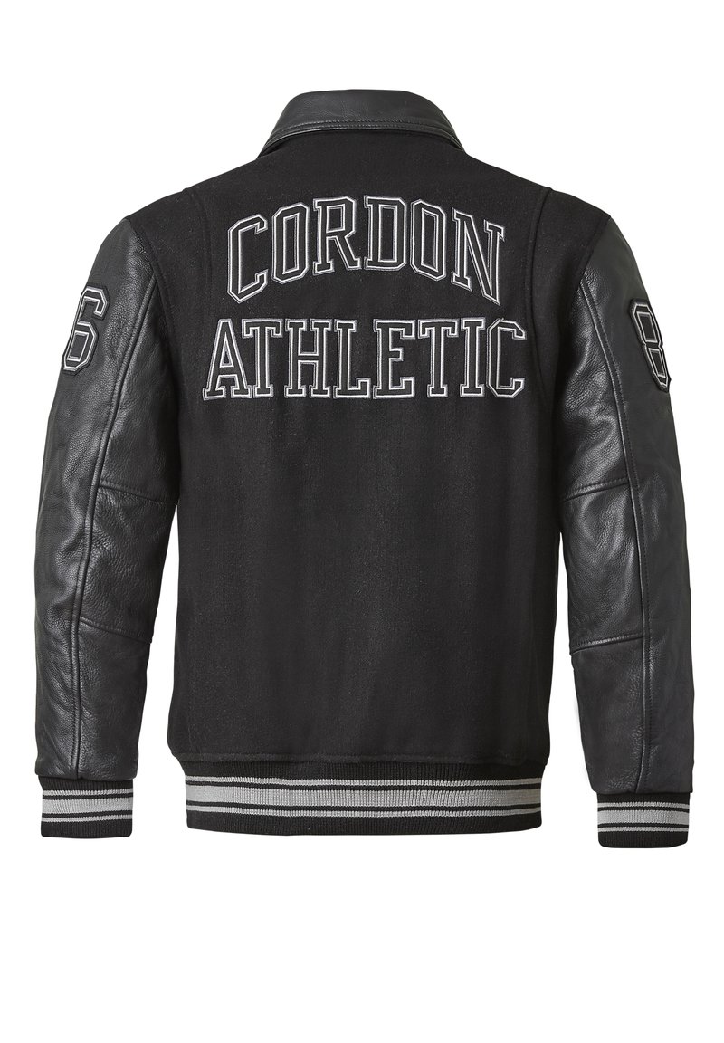Schwarze Varsity-Jacke mit Lederärmeln, einem Wollkörper und gerippten Abschlüssen. "Cordon Athletic" auf dem Rücken mit den Nummern 8 und 6 bedruckt.