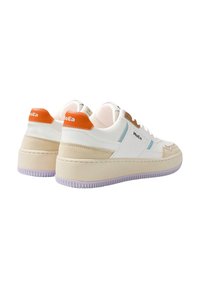 Hvite sneakers med plattformsåle, med oransje og beige detaljer, glatte og semskede materialer, og en sydd designfunksjon.