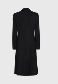 Abrigo de lana negro con una textura suave, mangas largas y un cuello clásico, diseñado con una silueta ajustada y costuras traseras.