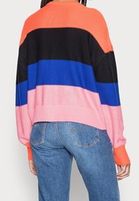 Truien met laten vallen schouders, voorzien van opvallende horizontale strepen in oranje, zwart, blauw en roze. Met geribde manchetten en een cropped zoom.