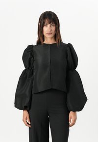 Černý zkrácený top s oversized, vypufovanými rukávy. Vyroben z hladké látky s matným povrchem, obsahuje jednoduchý, nezdobený design.