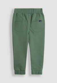 Grüne Baumwoll-Jogginghosen mit elastischem Bund, zwei Gesäßtaschen und gerippten Bündchen. Einfaches Design mit einer weichen Textur.