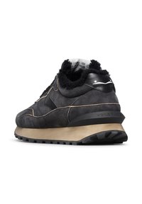 Sneaker in suede nera con colletto imbottito, suola beige, cuciture strutturate e dettagli in pelle nera. Presenta una suola esterna in gomma rigata.