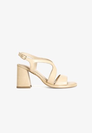 Beige leren blokhak sandaal met een uitsnijdingsontwerp, verstelbare enkelband en open teen. Gladde textuur met minimale accenten.