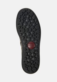 Suola di scarpa con motivi circolari neri di varie dimensioni e un cerchio centrale rosso rilievato con la scritta "camper" e la misura della scarpa "38".