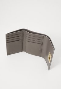 Grey leather tri-fold wallet with multiple card slots and a gold-tone clasp on a white background.