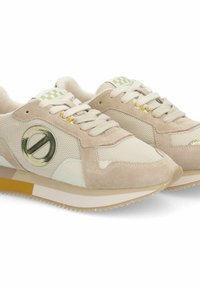 Sneaker beige in materiali mesh e suede, con un logo metallico rotondo, dettagli testurizzati e una suola bianca e beige a contrasto.