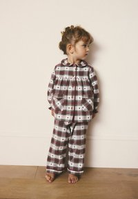 Rot-weiße karierte Flanellschlafanzüge mit einem Kragenhemd und zwei Fronttaschen, die kleine Herzmuster aufweisen, kombiniert mit passenden Hosen.