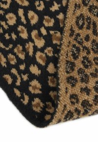 Leopardenmuster-Wurfdecke in einer Kombination aus Beige und Schwarz, mit weicher Textur und zwei unterschiedlichen Mustern. Die Ränder sind sauber verarbeitet.