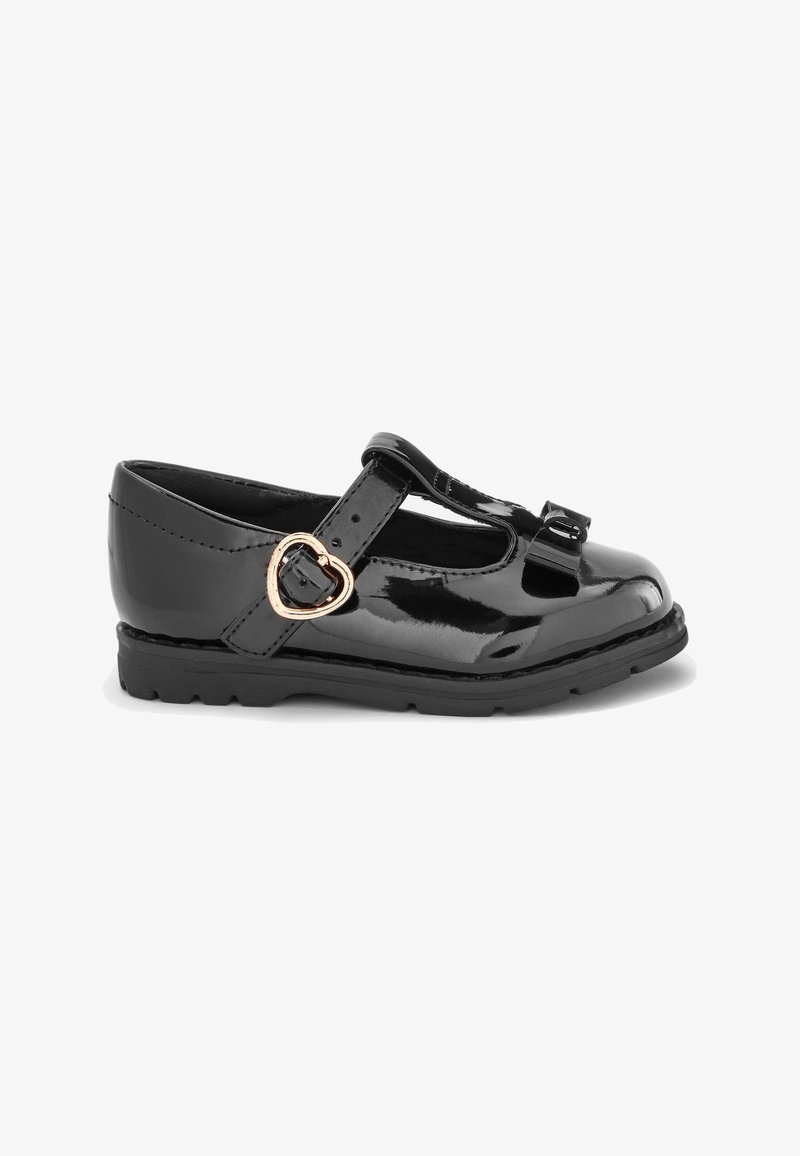 Chaussure Mary Jane en cuir verni noir avec un bout arrondi, une sangle ajustable et un détail de boucle en forme de cœur. Semelle en caoutchouc épaisse pour une durabilité accrue.