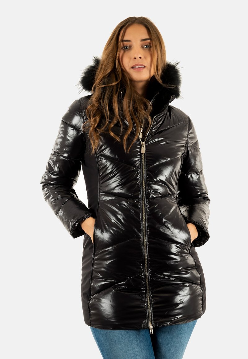 Giacca a vento nera con tessuto lucido e trapuntato e cappuccio foderato in pelliccia. Presenta chiusura con zip, tasche laterali e una silhouette aderente.
