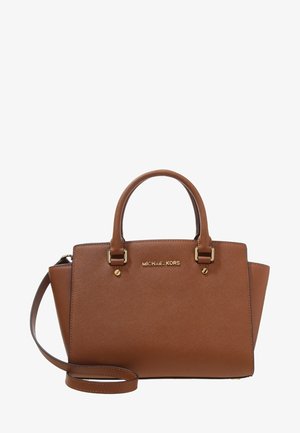 Brun læder Michael Kors håndtaske med dobbelthanke, guldfarvet beslag og aftagelig skulderrem på hvid baggrund.