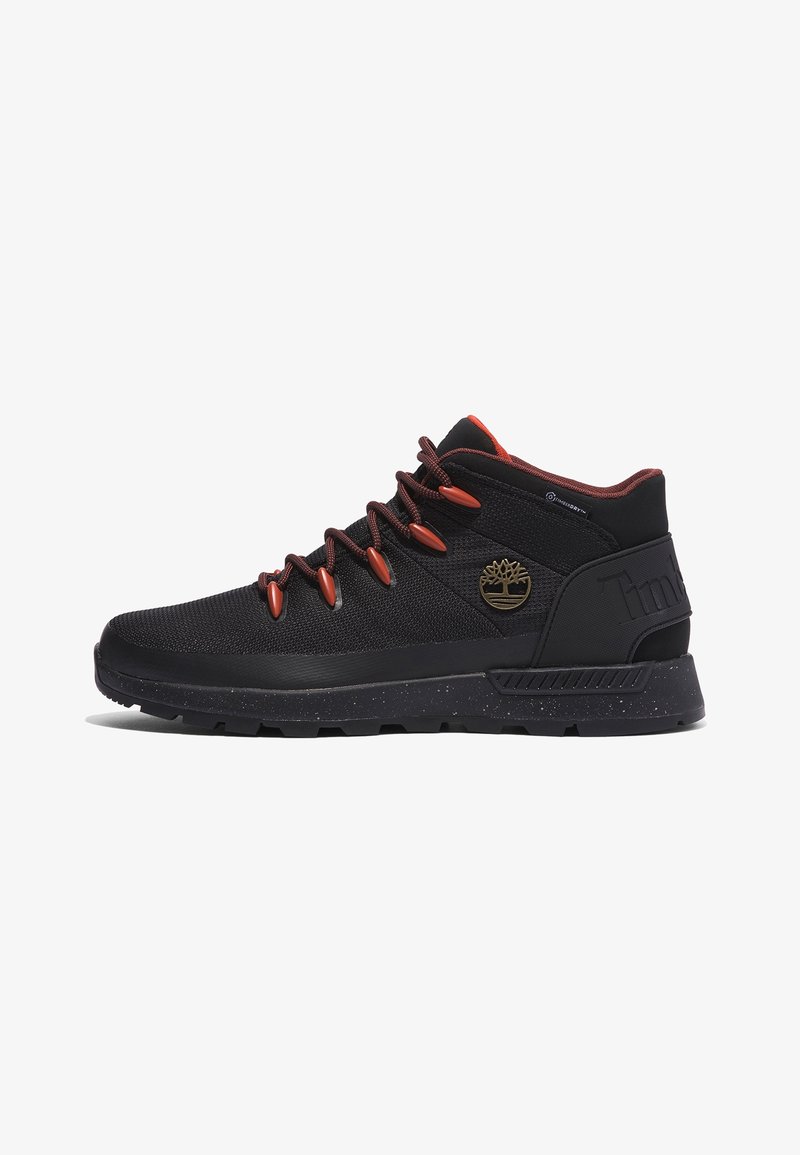 Baskets montantes noires avec lacets rouge foncé, œillets orange, semelle texturée et logo arbre doré sur le côté.