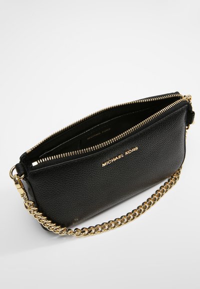 Pochette en cuir noir avec une bandoulière en chaîne dorée, dotée d'une fermeture zippée sur le dessus et d'un logo embossé à l'avant. Détail de surface texturé.