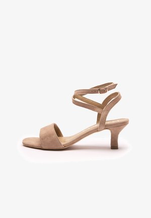 Sandale pour femme en daim beige avec talon bas, ouverture à l'avant et bride autour de la cheville avec une petite boucle dorée.