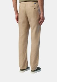 Pantaloni in lino khaki con una vestibilità rilassata, dotati di due tasche posteriori, una trama sottile e un'etichetta blu e bianca in vita.