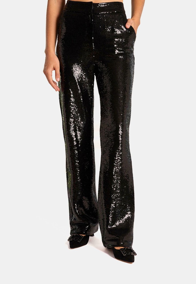 Pantalons à sequins noirs avec une coupe large, dotés d'une taille haute, de poches et d'une texture brillante qui reflète la lumière. Accentué par une finition lisse.