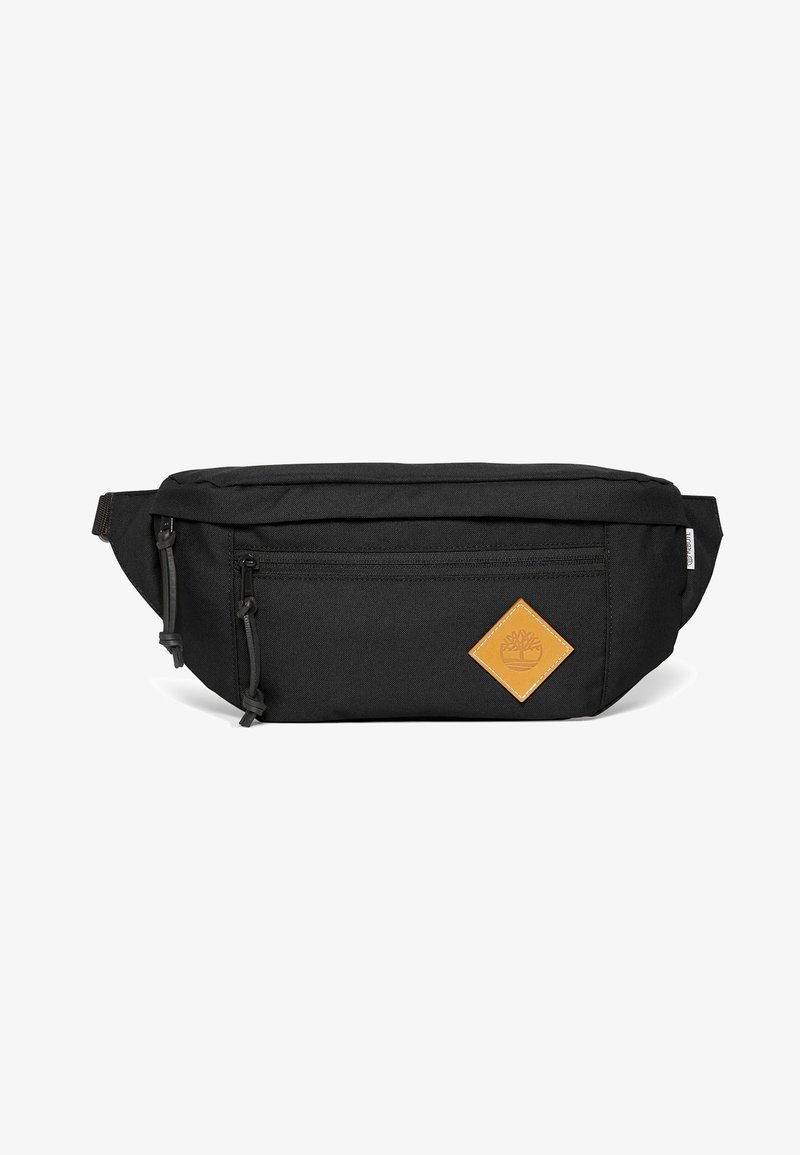 Sac banane en tissu noir avec poche avant zippée, sangle réglable et écusson en cuir marron avec un logo d'arbre en bas à droite.