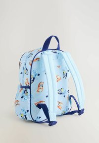 Világoskék hátizsák rajzfilmfigurás mintákkal, felső fogóval és állítható kék pántokkal. Puha szövet és cipzáras rekesz.