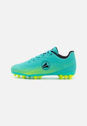 Scarpe da calcio verdi con una parte superiore in sintetico testurizzato, dotate di accenti gialli, dettagli neri e sei tacchetti gialli sulla suola.