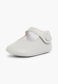 Zapato de bebé de cuero gris con punta redonda, borde festoneado y correa de Velcro. Textura suave con un forro interior blando.