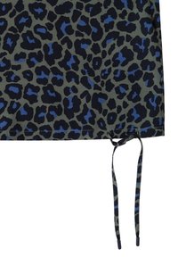 Ourlet à cordon avec imprimé léopard bleu et noir sur tissu gris foncé.