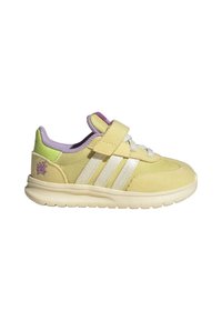 Yellow suede sneaker with white stripes, velcro strap, purple accents, and a green heel tab. Features textured outsole for grip.