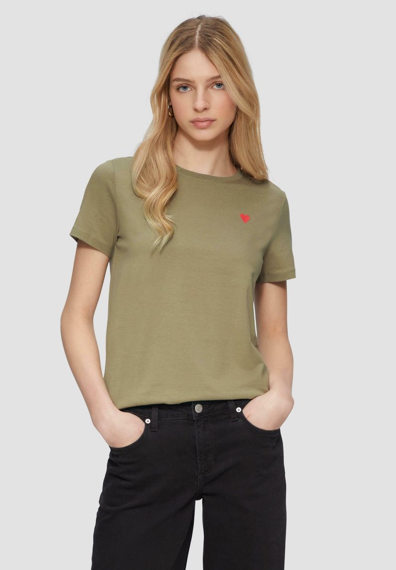 Oliwkowa bawełniana koszulka z krótkim rękawem i okrągłym dekoltem, z małym haftowanym czerwonym sercem na lewej piersi.