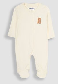 Body per neonati color crema realizzato in morbido tessuto, con maniche lunghe, gambe con piedi e una grafica di orsetto marrone sul petto.