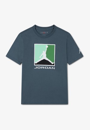 T-shirt bleu marine à col rond avec un logo carré vert et vert clair, représentant la silhouette blanche d'un joueur de basket-ball et le texte "JORDAN" en dessous.
