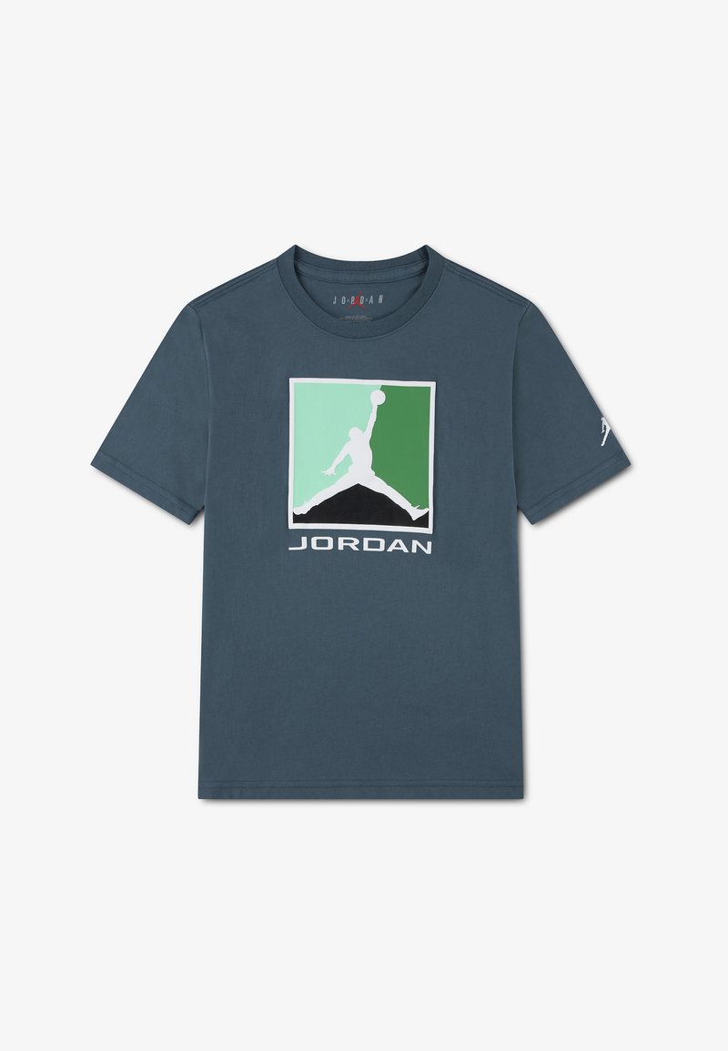 T-shirt bleu marine à col rond avec un logo carré vert et vert clair, représentant la silhouette blanche d'un joueur de basket-ball et le texte "JORDAN" en dessous.