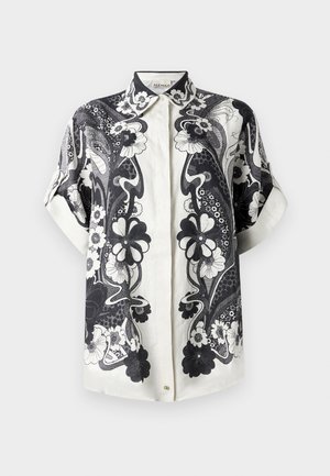Kortærmet skjorte med knapper, lavet af let stof, der har et sort/hvidt blomstermønster med detaljerede designs og en spids krave.