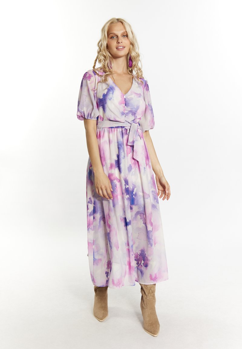 Rochie maxi dintr-un material ușor și transparent, cu un model în acuarelă în nuanțe de roz și violet. Dispune de mâneci bufante, un cordon la talie și detalii cu nasturi.